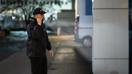TrustForce security officer conducting a night patrol with a torch, reflecting the company's 24/7 Operations Center coverage and round-the-clock manned guarding standards in Qatar.